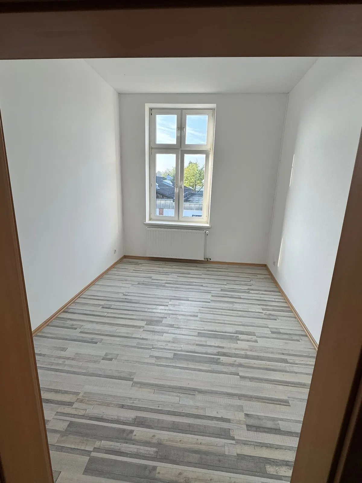 Lege kamer in Den Bosch met strak wit geschilderde wanden en een raam met roedes